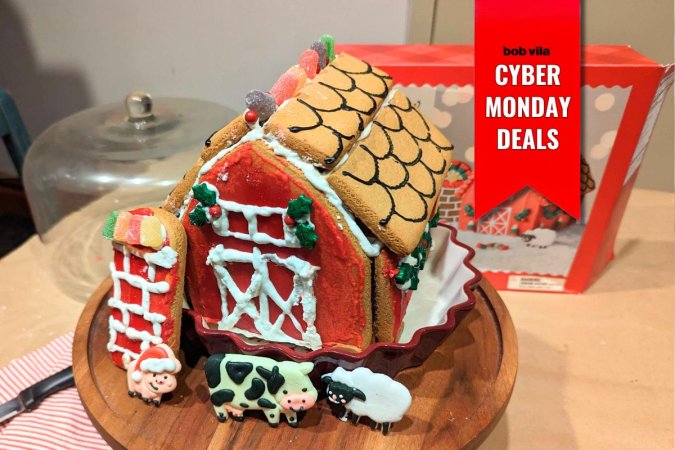 Completed Gingerbread Barn Kit, Decorated in Red Icing, Standing in Front of Its Box