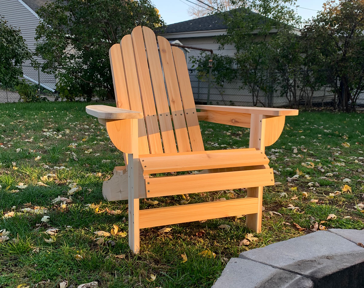 A diy Adirondack chair in a suburban backyard near a fire pit.