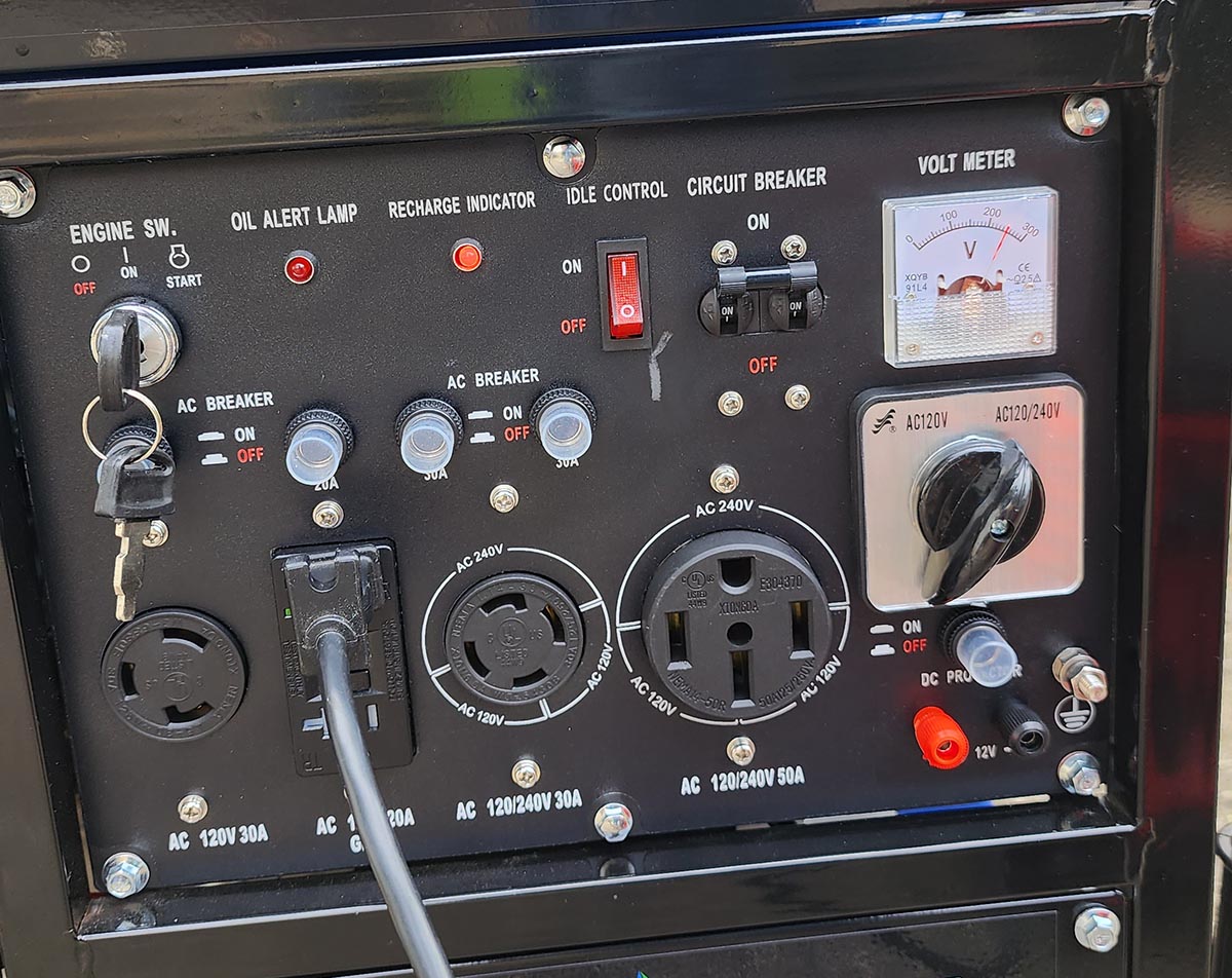 The control panel of the DuroMax XP12000EH with an AC cord plugged in.