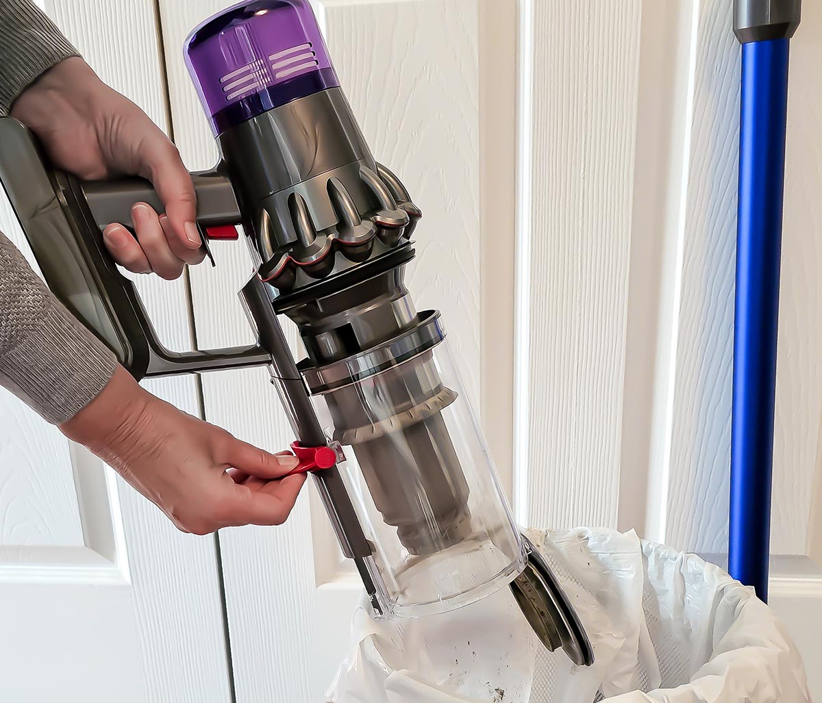 Person empty the dust canister of a Dyson V11 Animal stick vacuum