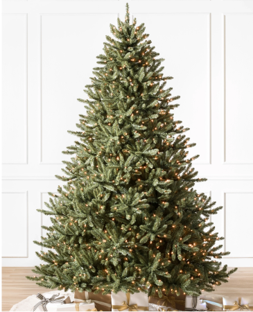 Balsam Hill Christmas tree set up in a room with a tree skirt and presents under it