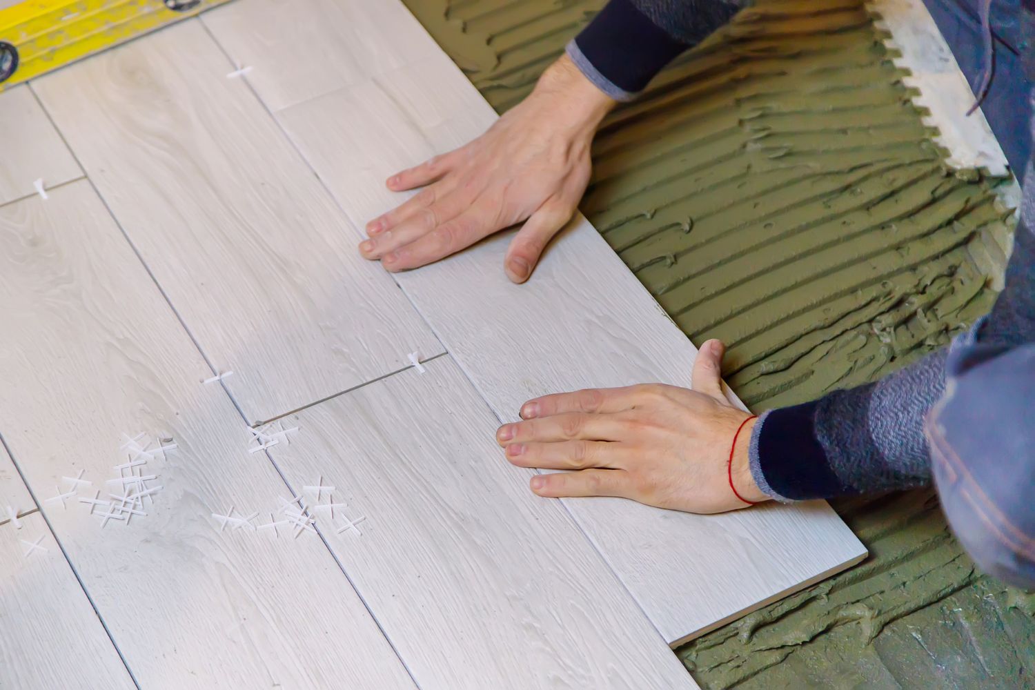Expert Craftsman Installing Engineered Wood Floor in a Residential Home, Highlighting the Texture and Quality of the Material.