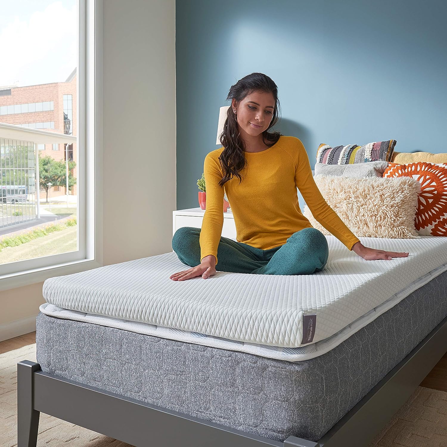 Teenager Sitting on a Tempur Adapt Cooling Mattress Topper on Twin XL Bed, Now on Sale for Cyber Monday
