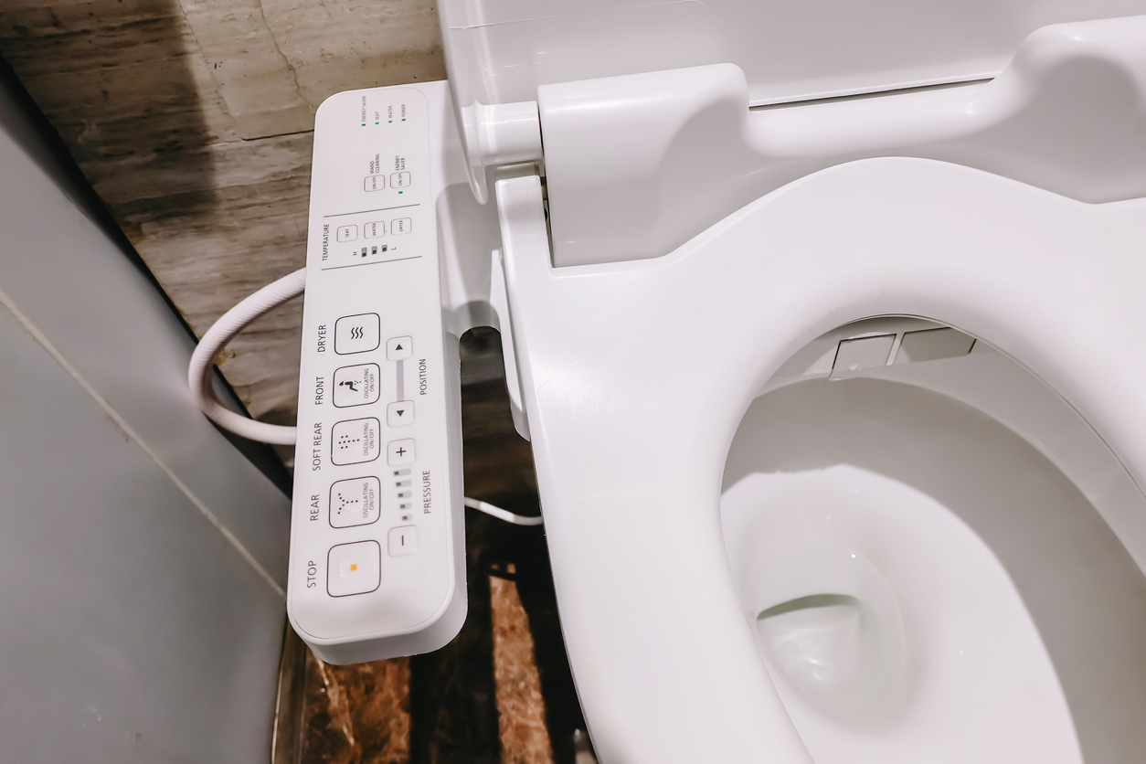 The on-seat control panel of the best bidet toilet seat next to an open toilet.