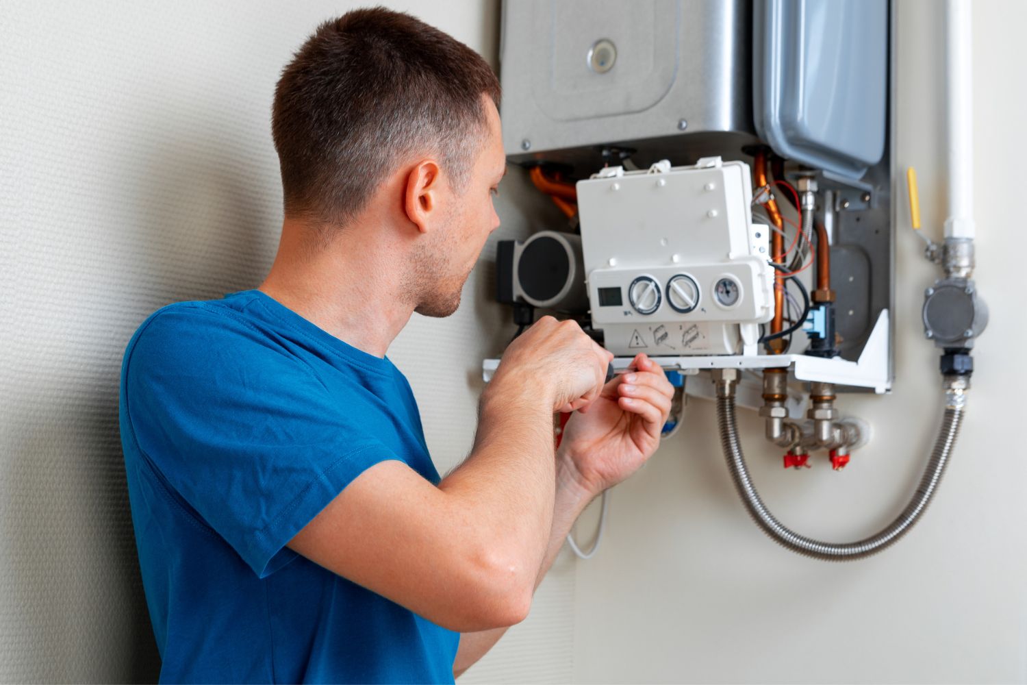How Much Does a Boiler Service Cost: Boiler service cost depicted by a technician fixing a boiler