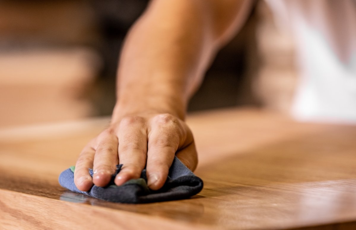 Young Carpenter Rubbing Oil Into wood countertop or tabletop.