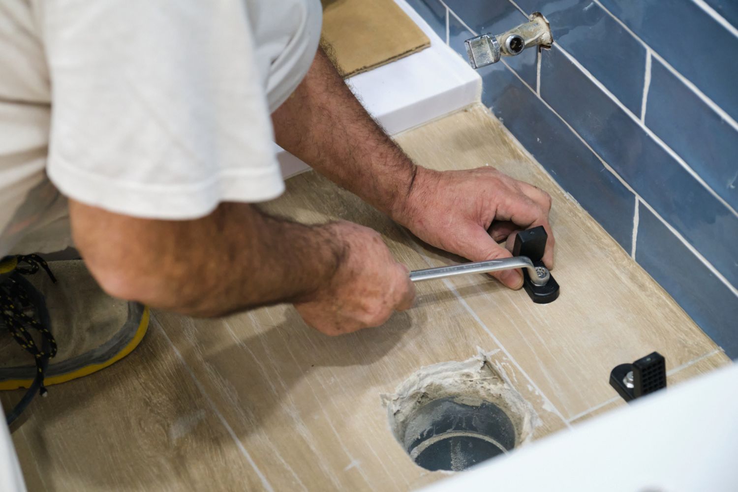 How Much Does It Cost to Replace a Toilet Flange: Expert plumber conducting a toilet flange swap