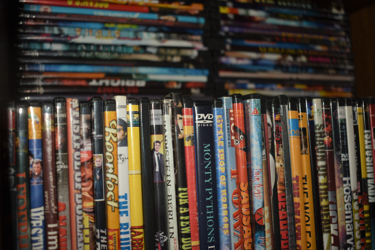 A close view of a collection of DVDs on a shelf.
