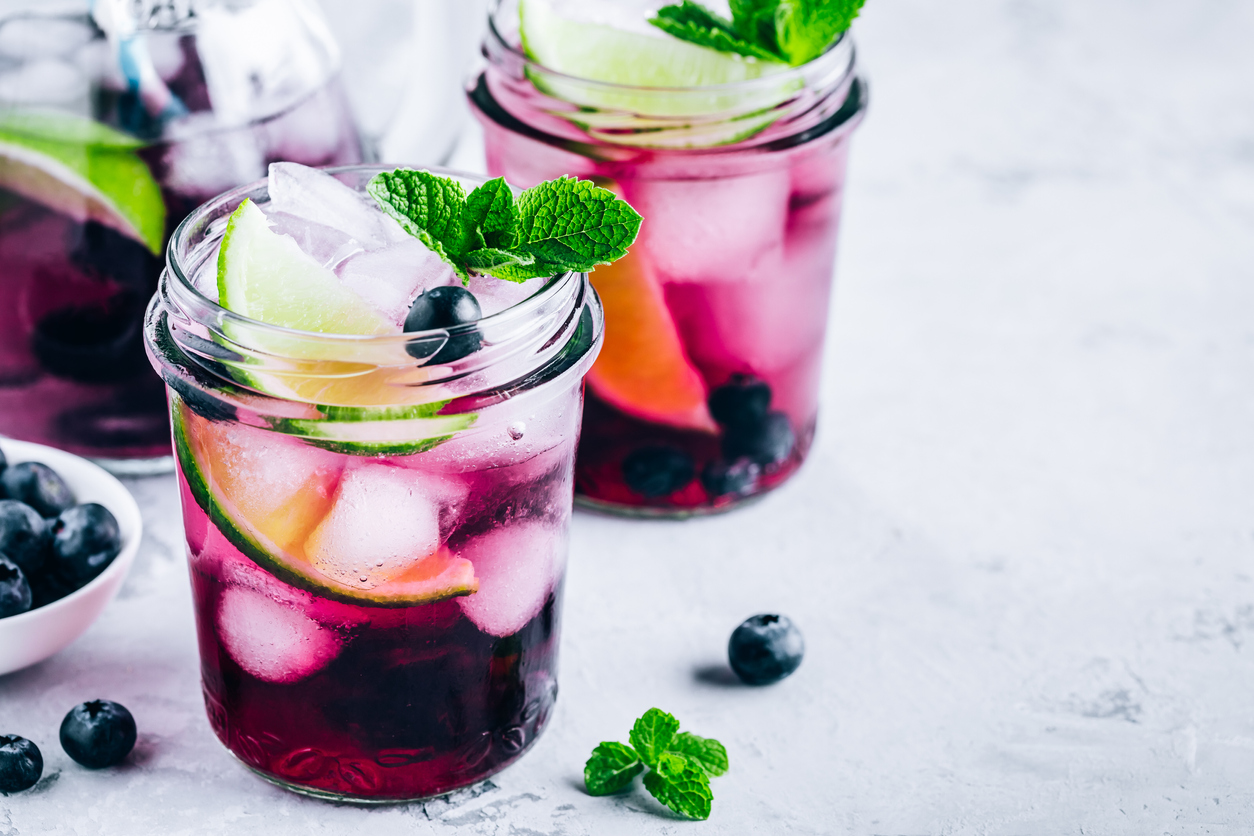 Blueberry Mojito with lime and fresh mint. Iced cold summer drinks in glass jar.