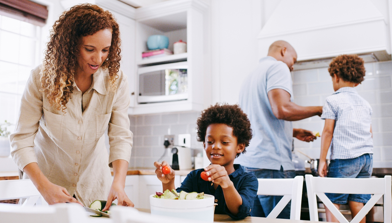 Cooking, kitchen and black family parents with children prepare food ingredients, supply or consumables for dinner, lunch or brunch. Fruit salad, wellness health and nutritionist mom help makes meal