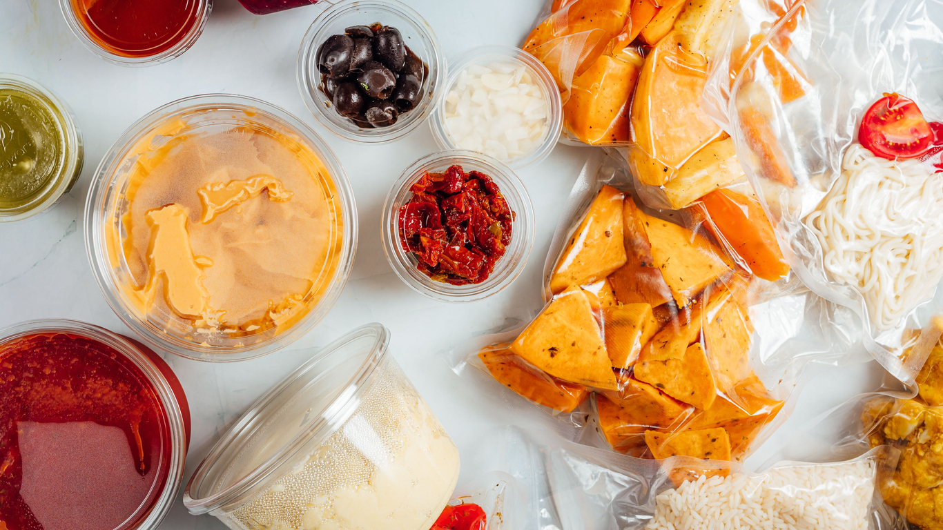 A top view of snacks and servings of food in plastic containers