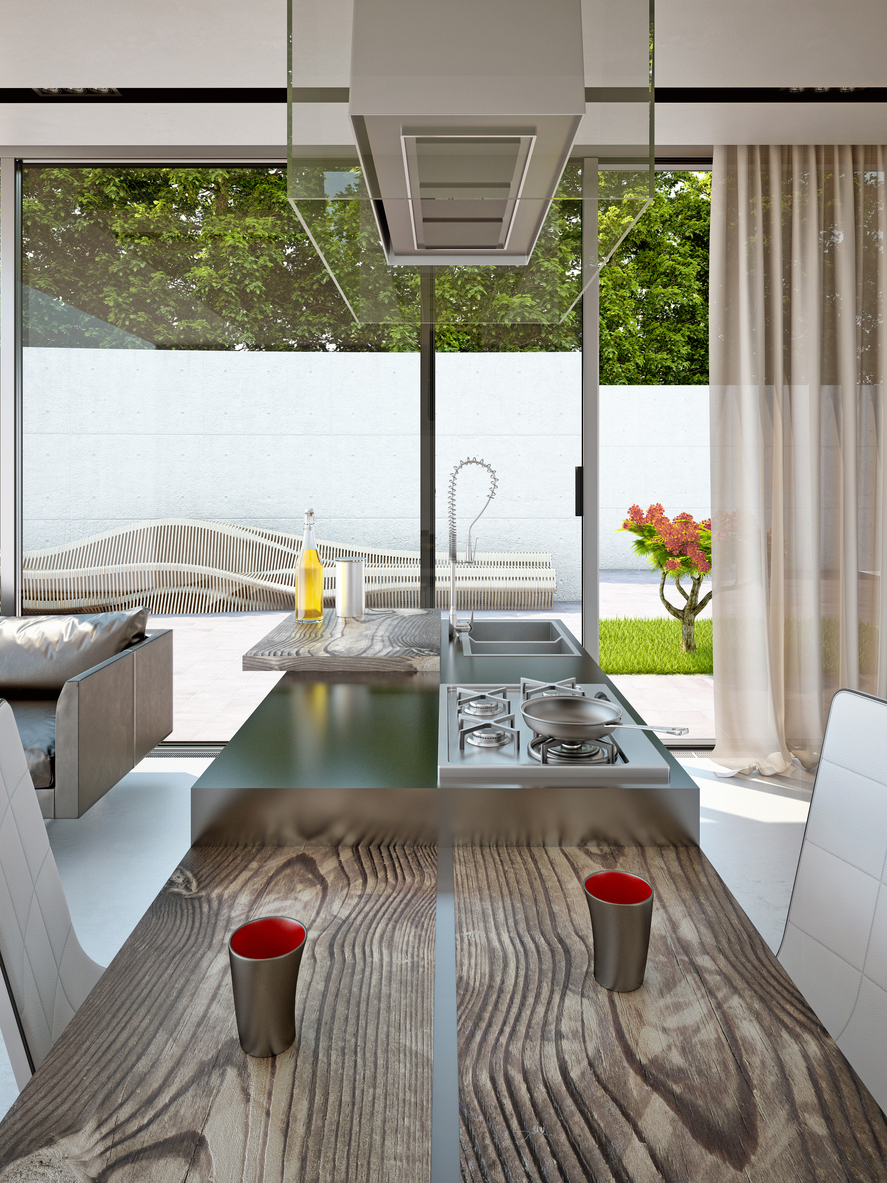 An indoor outdoor kitchen with large window covered partially with a tan sheer curtain.
