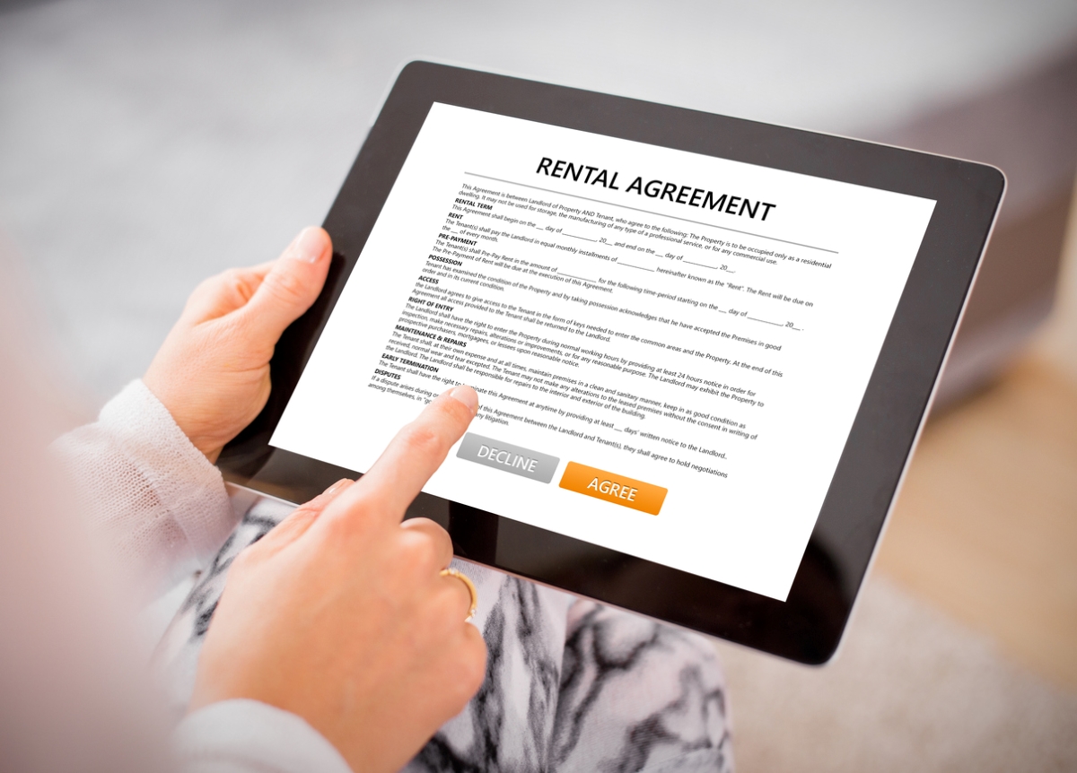 Person reading rental agreement on tablet.