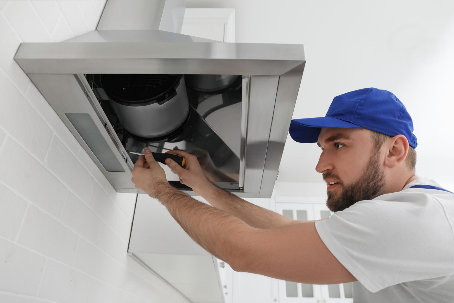 How Much Does Range Hood Installation Cost: Electrician wiring a range hood during a professional installation service