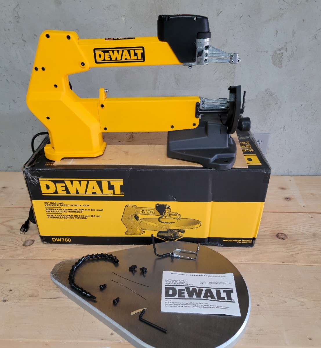 The DeWalt skill saw on top of its box and next to the small number of pieces that require assembly.