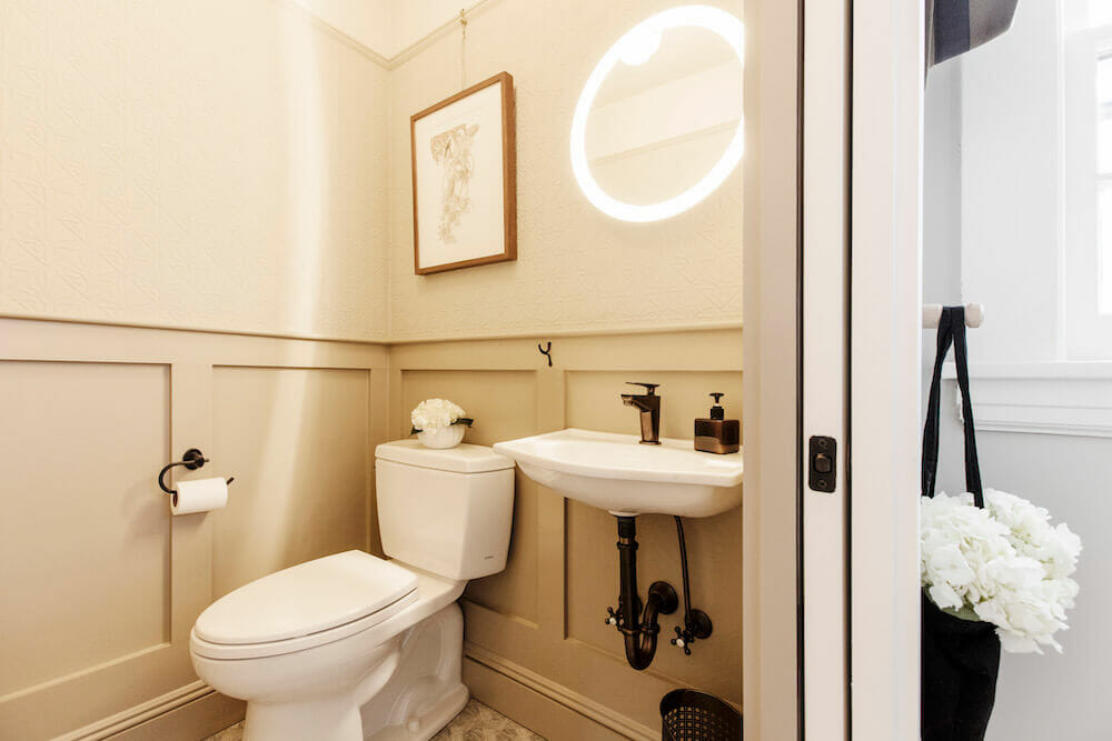 A warm-lit half-bathroom in a renovated old house.