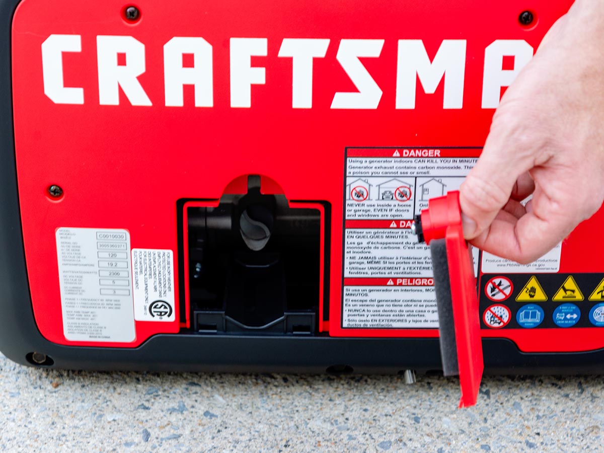 A person holding the oil cap on the Craftsman 3000-watt inverter generator before adding oil.