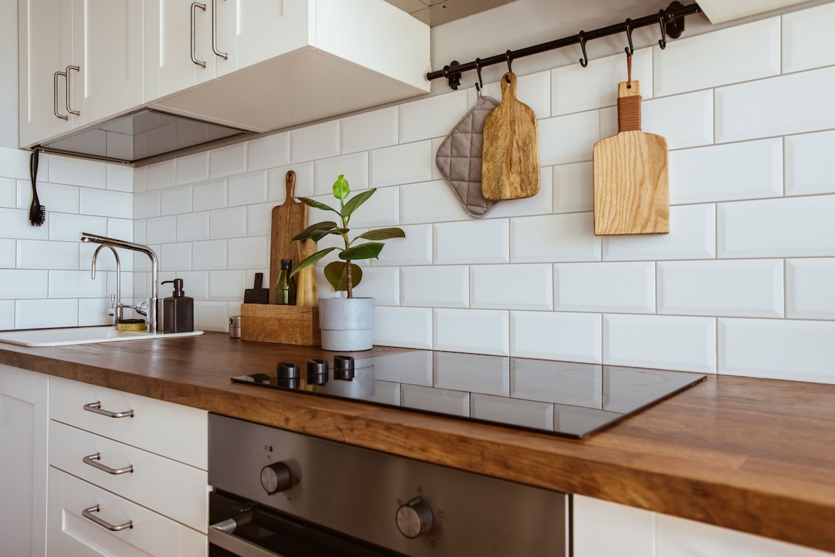 A kitchen backsplash with white subway tiles and beige grout.