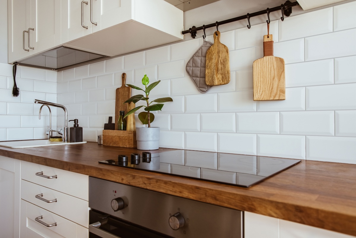 A kitchen backsplash with white subway tile and soft gray grout.