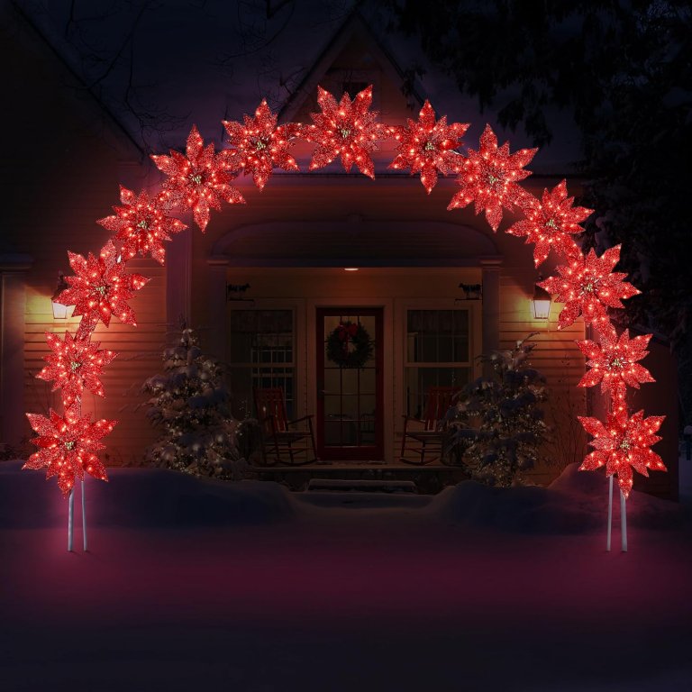 Mr. Christmas Poinsettia arch illuminated at night in front of a house.