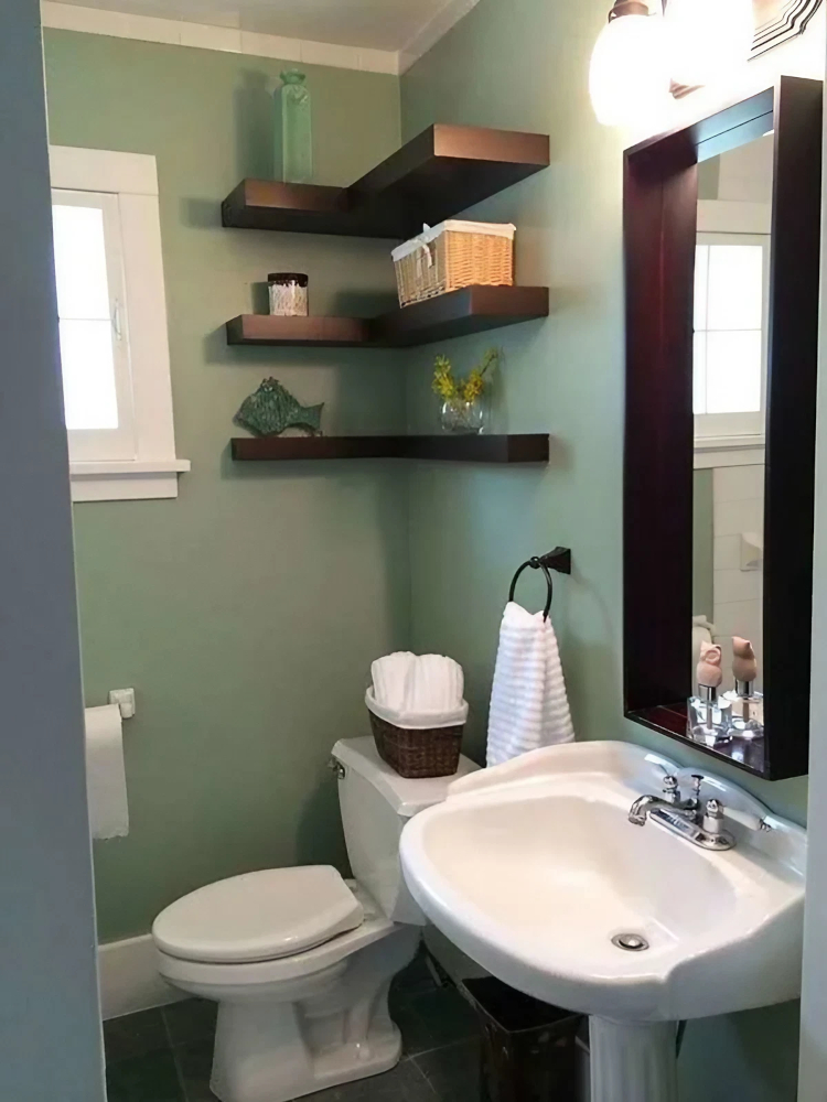A half-bathroom with earthy green walls and dark wood accents.
