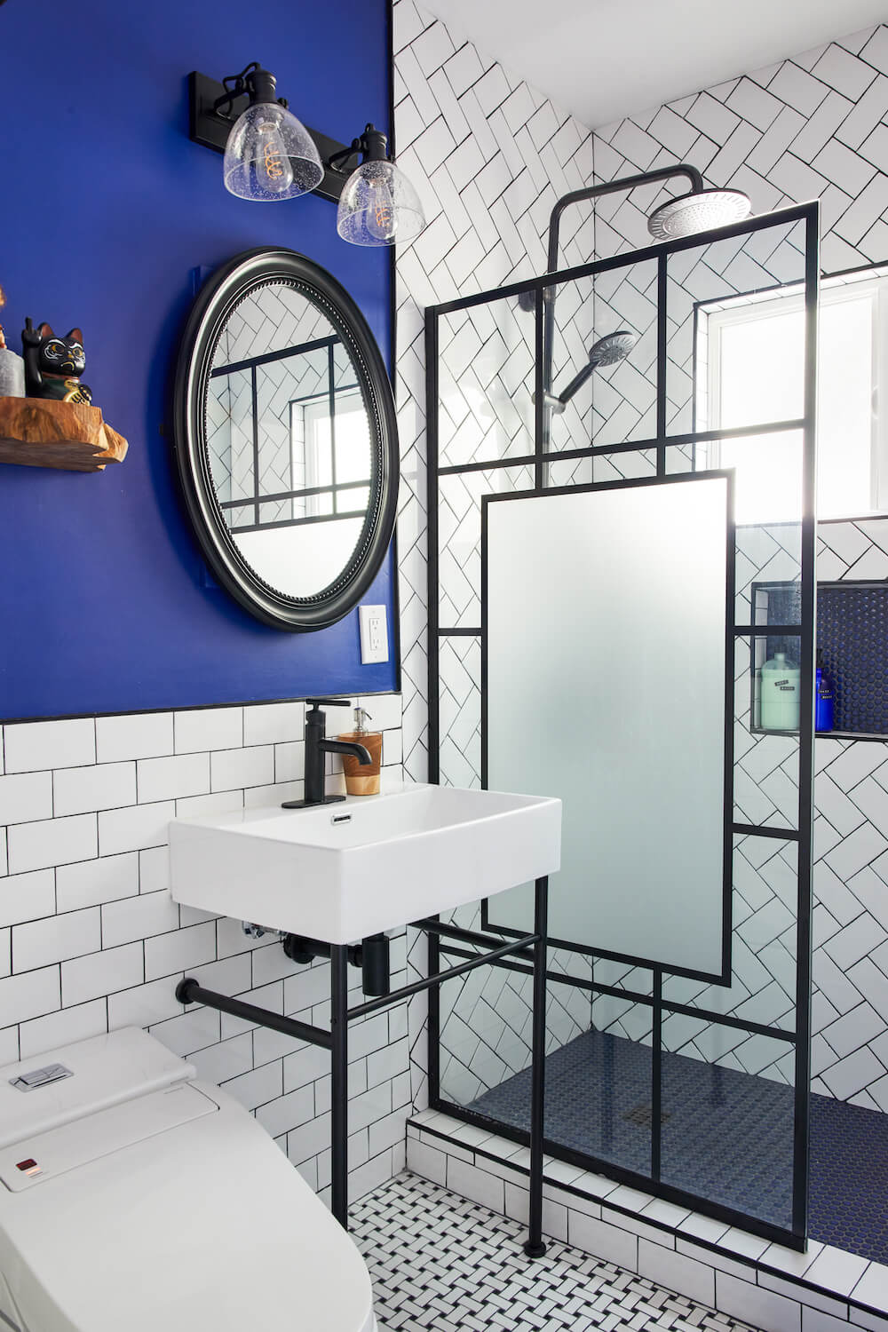 A small bathroom with a doorless walk-in shower and black metal fixtures.