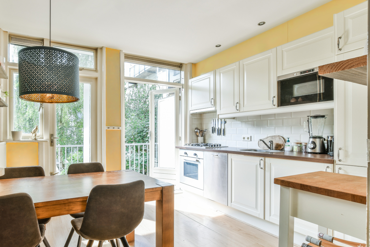 A bright, warm kitchen and dining room with yellow accent paint.