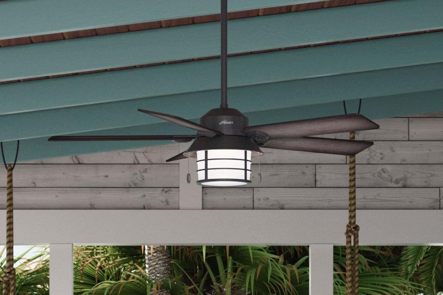 The Hunter Fan Company Key Biscayne Outdoor Fan installed over a patio to keep a seating area cool.