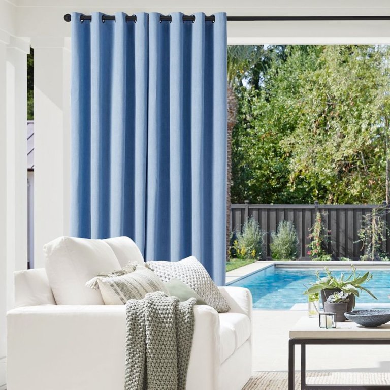  The Pottery Barn Outdoor Heathered Canvas Drape installed between a seating area and pool.