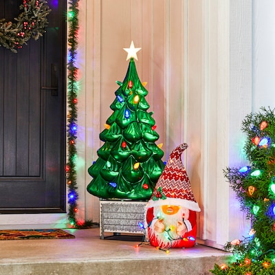 Blow mold vintage-style Christmas tree next to a front door.