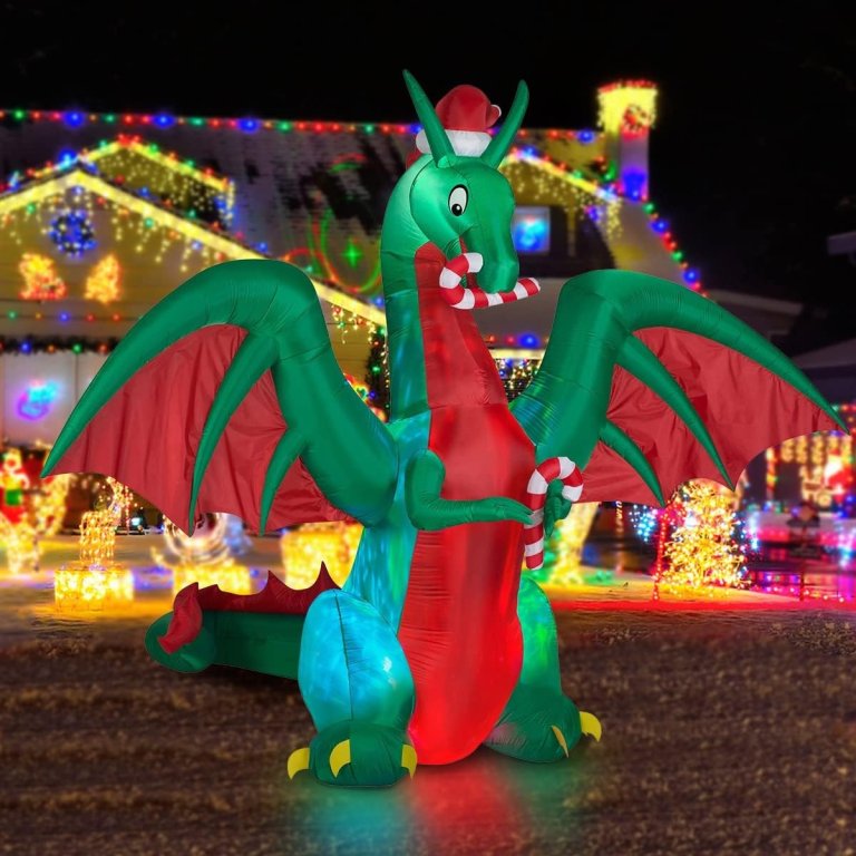 Christmas inflatable dragon wearing a Santa hat, in front of a house illuminated with Christmas lights.