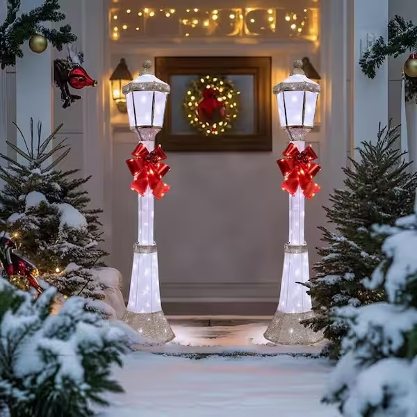 Two Christmas lamp posts glowing at the front entry of a house.
