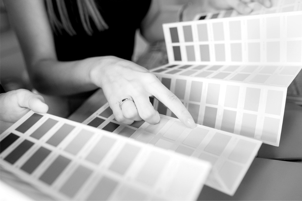 A woman points at a color sample on a paint color brochure.