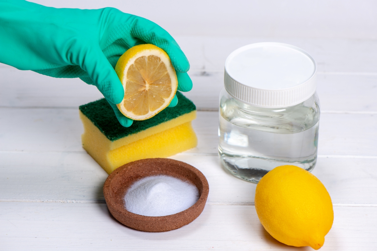 Person squeezing lemon to natural cleaning solution.