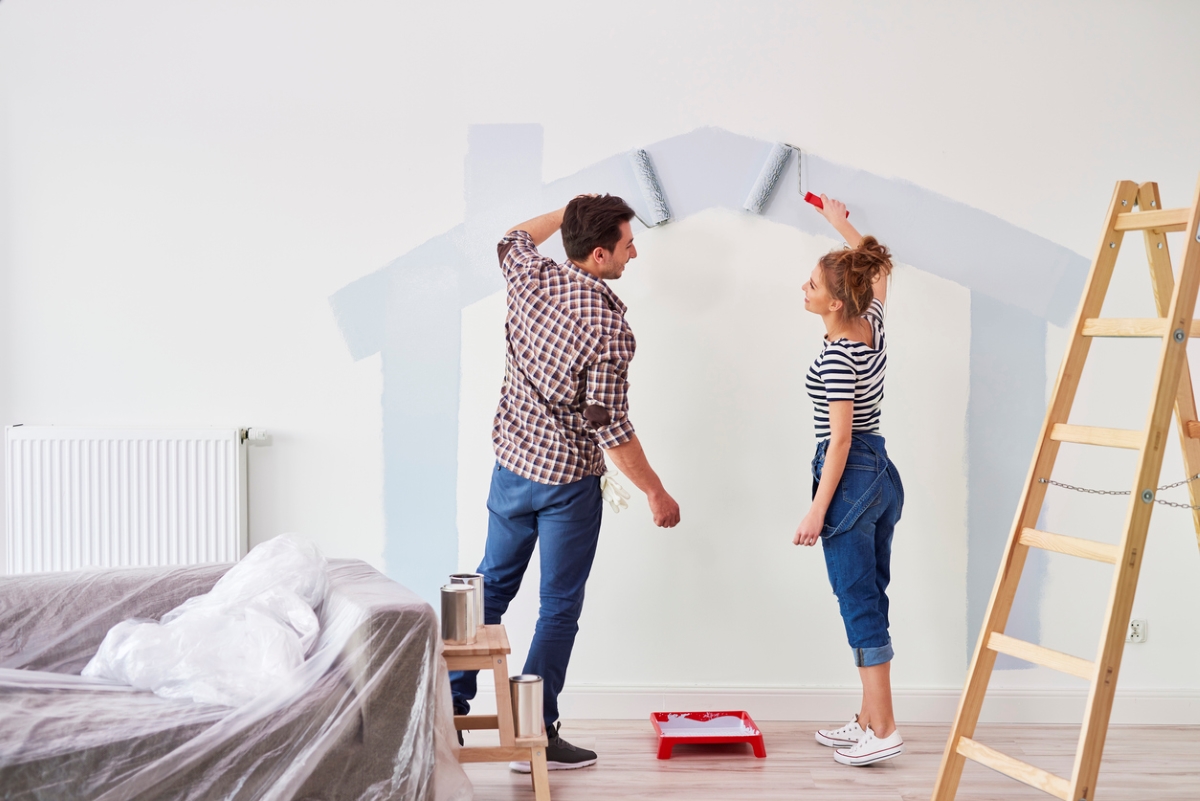 Couple painting wall.