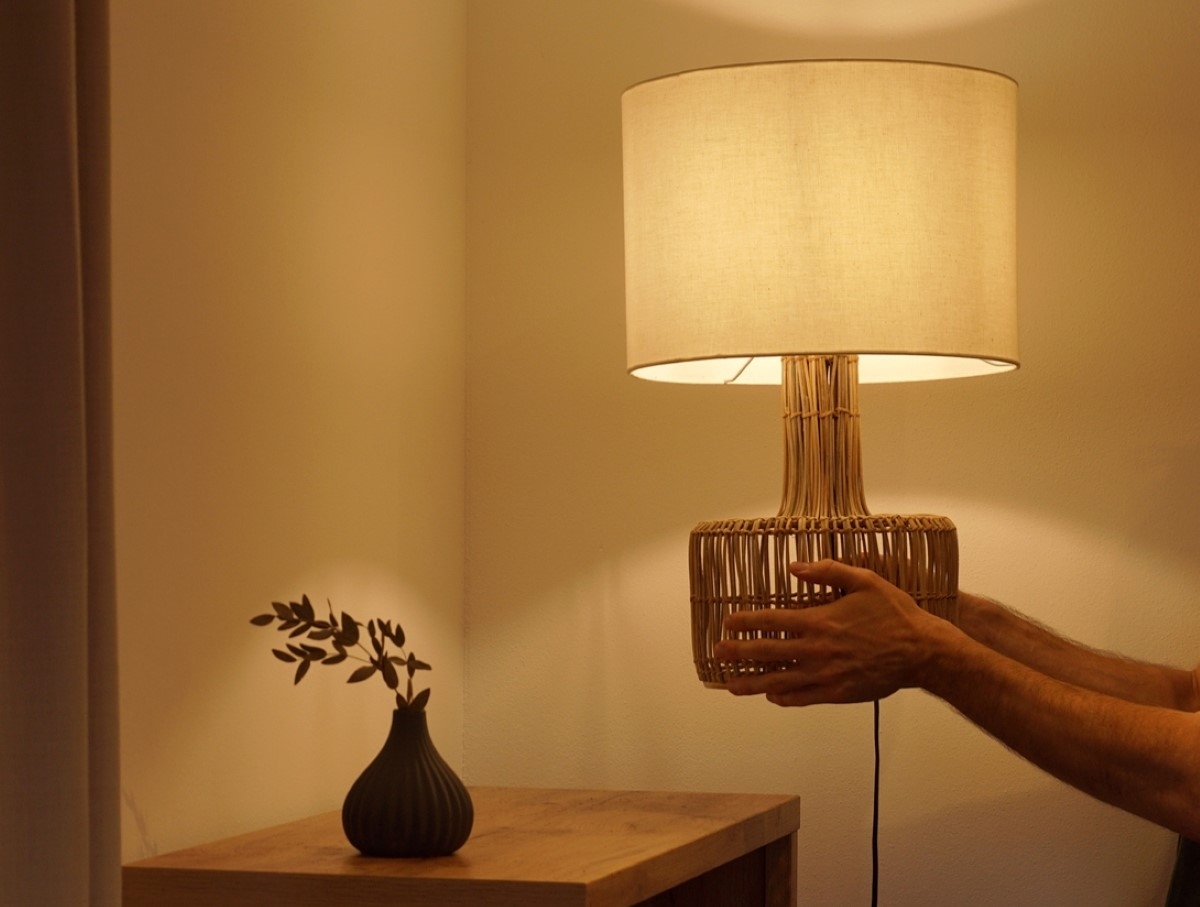 Person placing lamp with dim light on table.