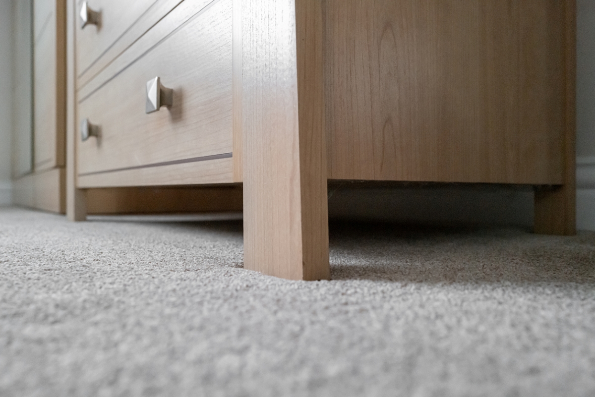Close up of furniture leg on carpet.