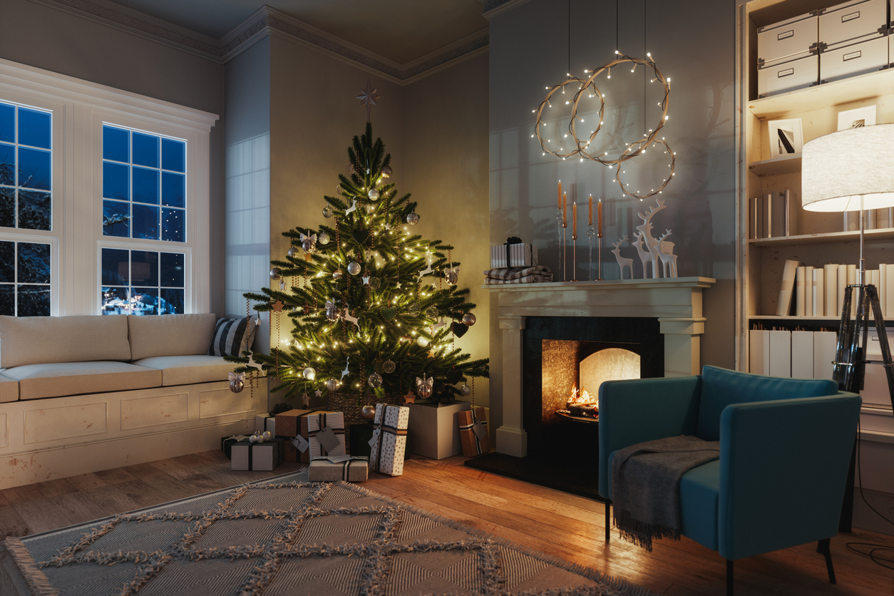 A-short-Christmas-tree-sits-in-the-corner-of-a-living-room-with-presents-and-winter-decor.
