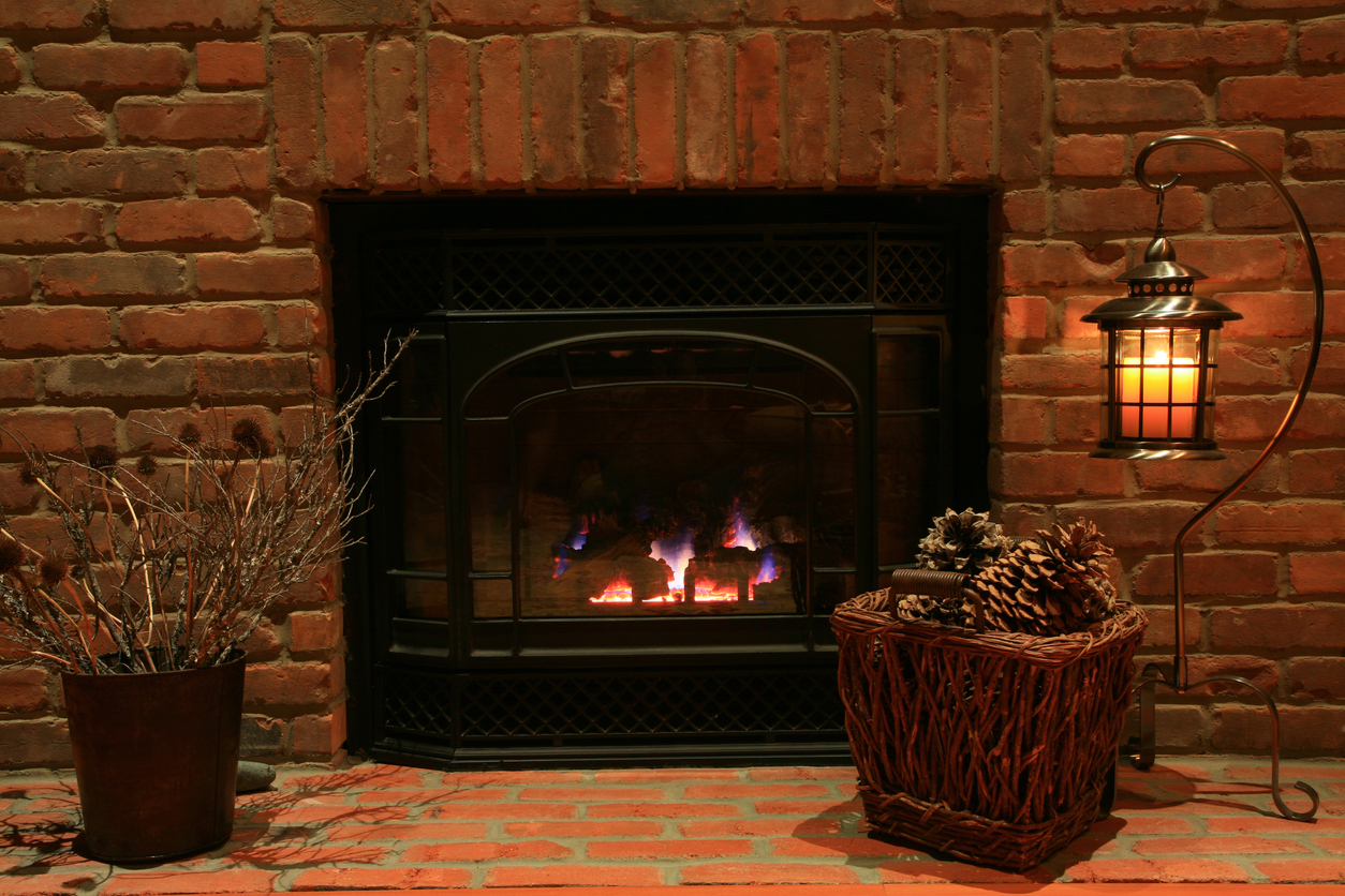 Cozy Hearth And Old Brick Fireplace with basket of pine cones.