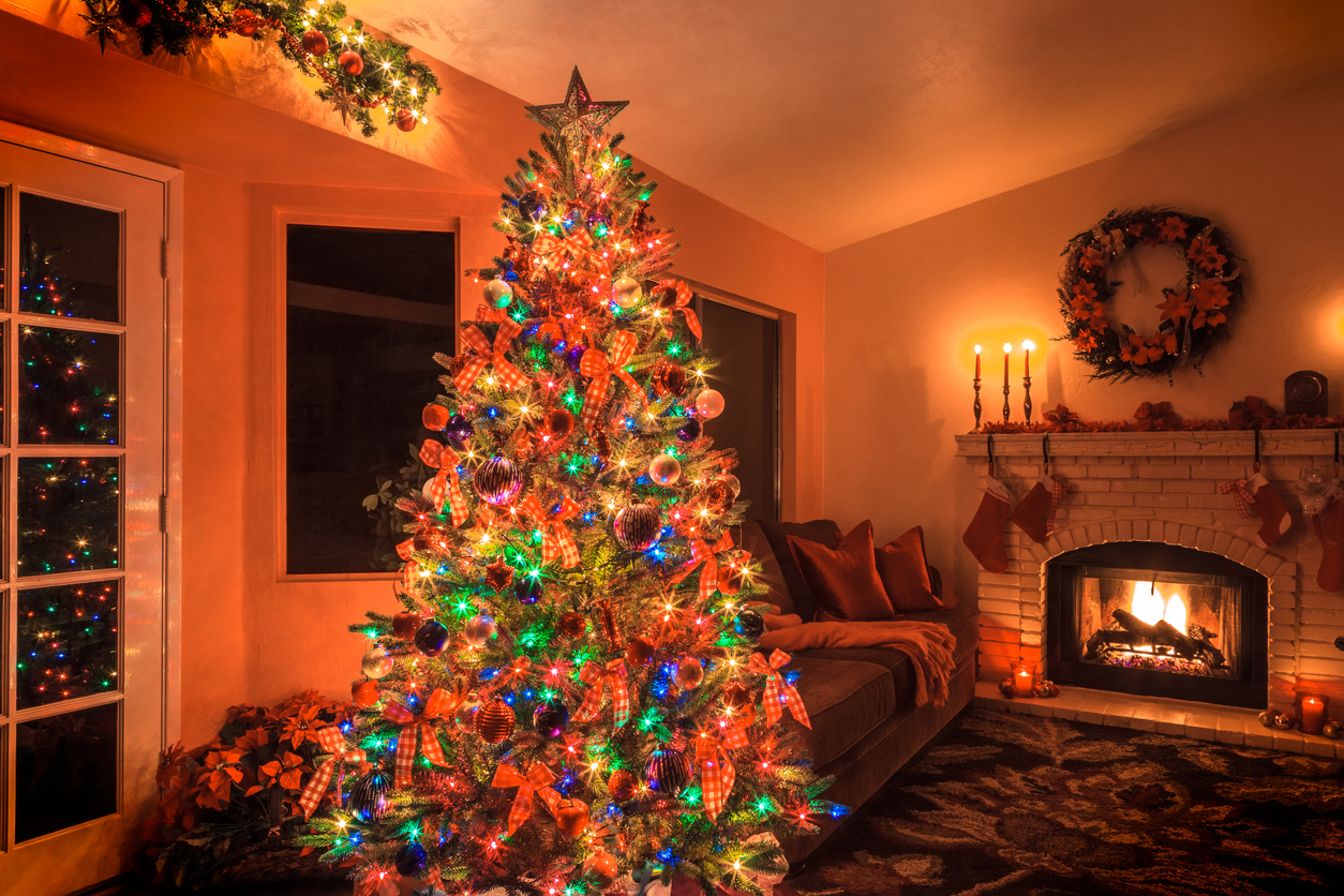 A-Christmas-tree-with-a-lot-of-multi-colored-lights-glows-in-a-living-room-with-a-fireplace.