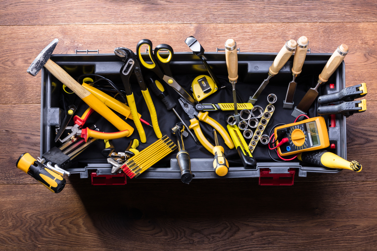 A-collection-of-yellow-and-black-tools-are-arranged-in-an-open-toolbox.