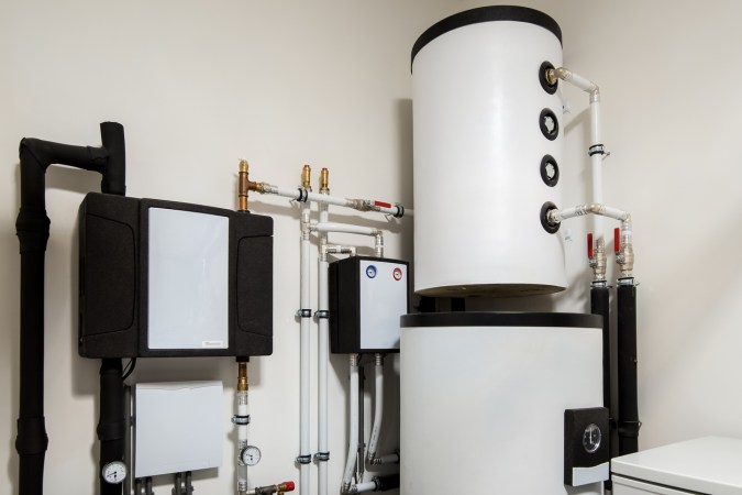 The Best Heat Pump Water Heater installed in a tidy utility room with white walls.
