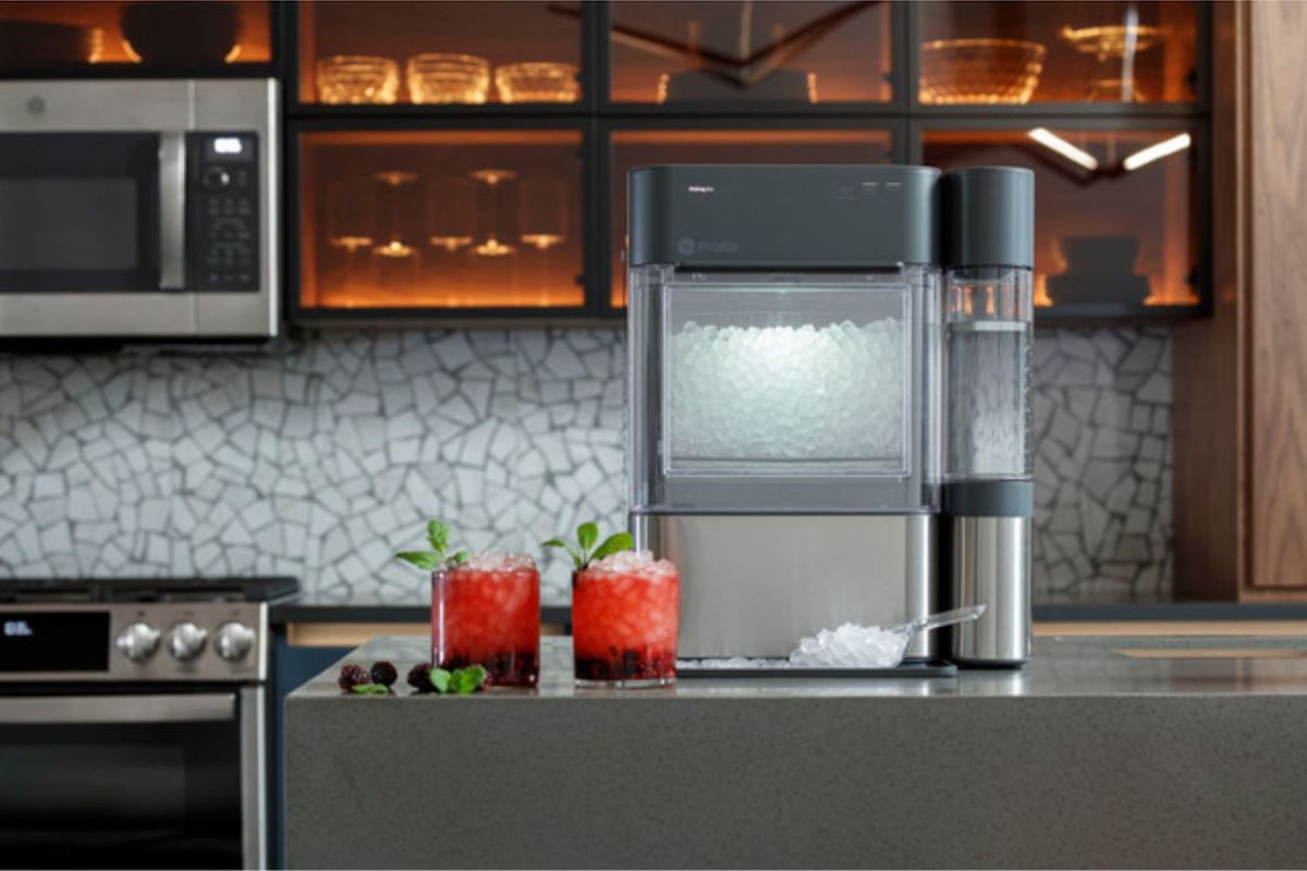 The GE Profile Opal 2.0 Nugget Ice Maker on a kitchen counter with two freshly made icy cocktails next to it.