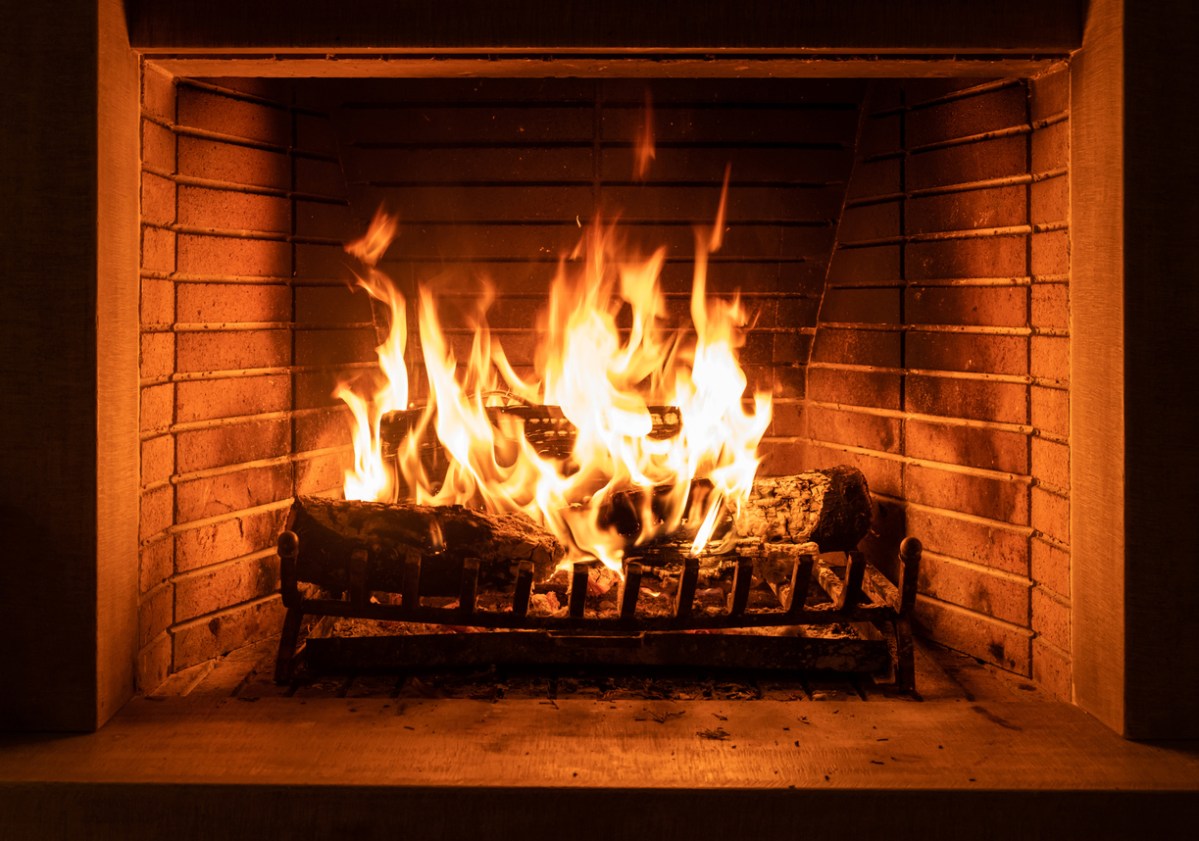 Roaring fire in indoor brick fireplace.