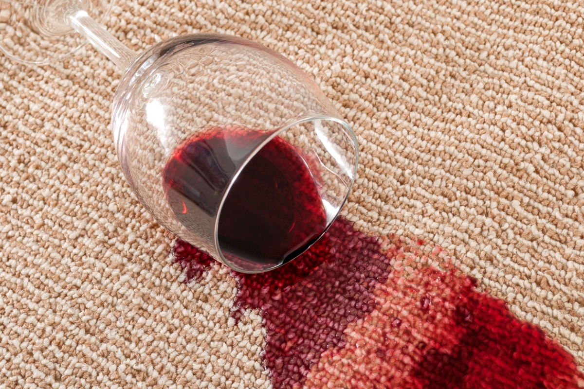 Red wine spilled on brown carpet.