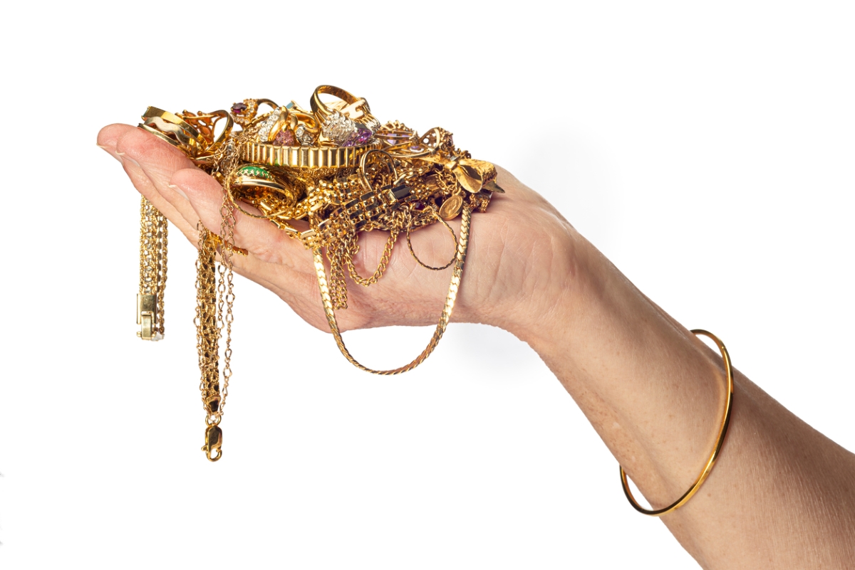 Person holding tangled gold jewelry in hand.