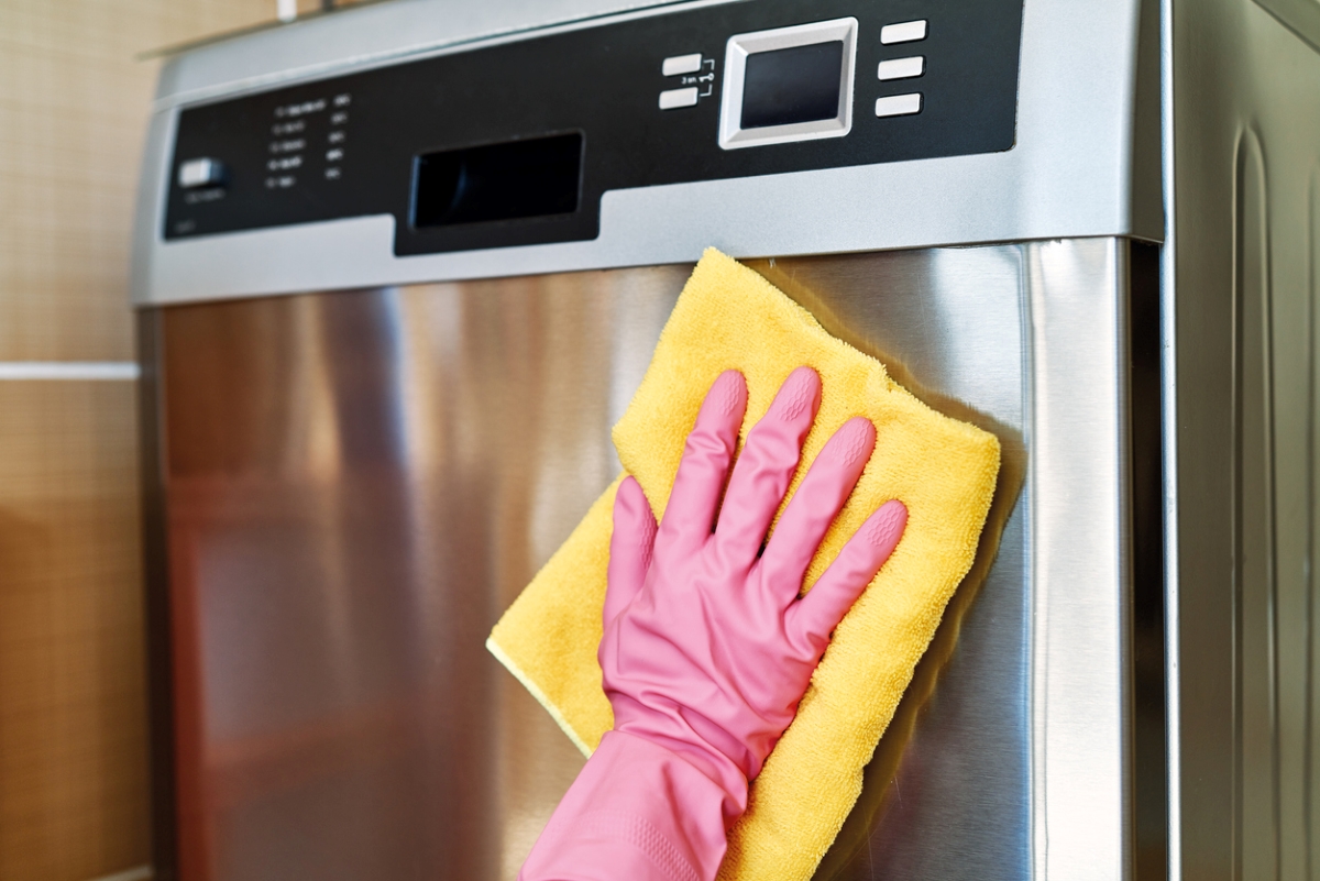 Using yellow rag to clean dishwasher.