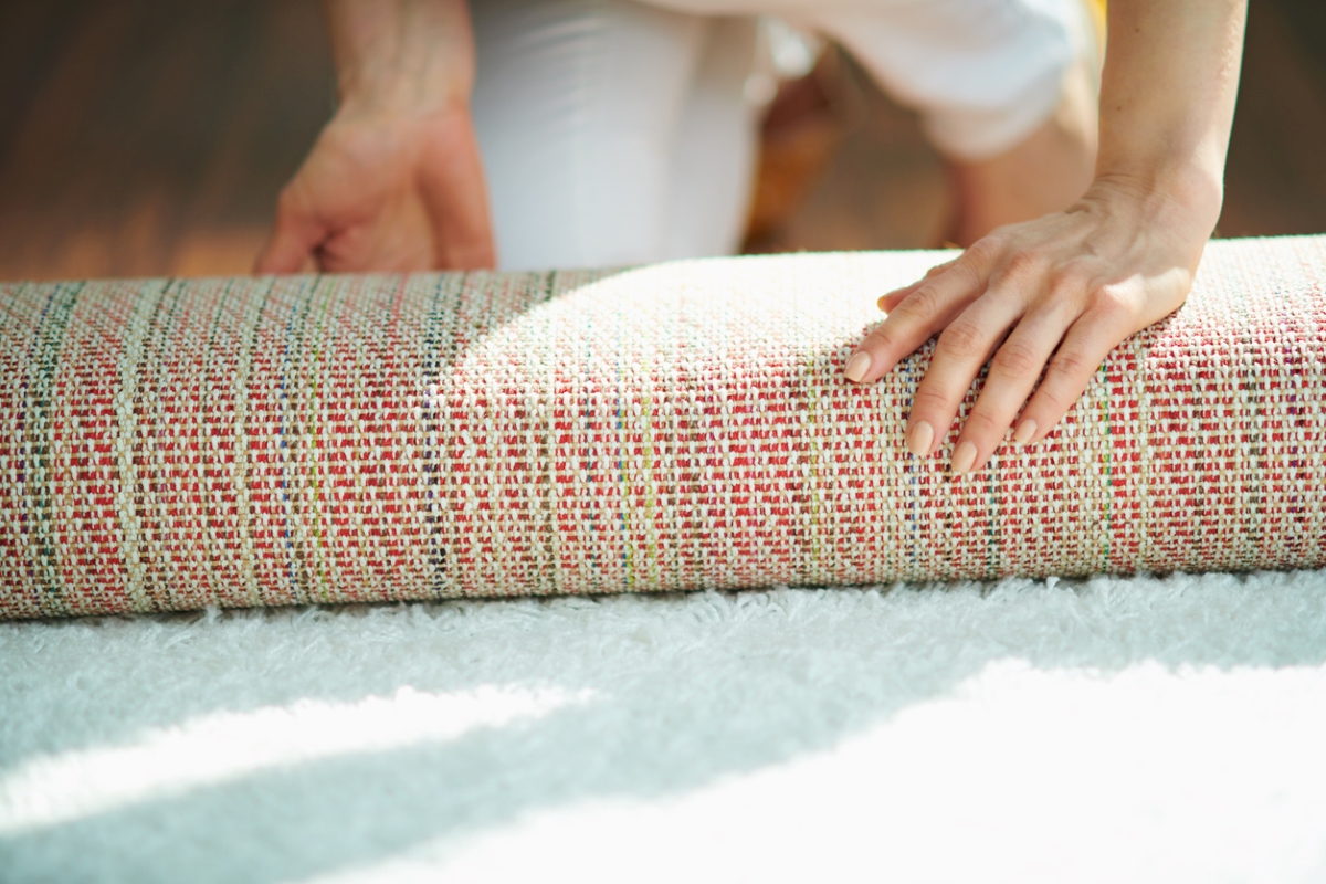 Hands rolling carpet rug.
