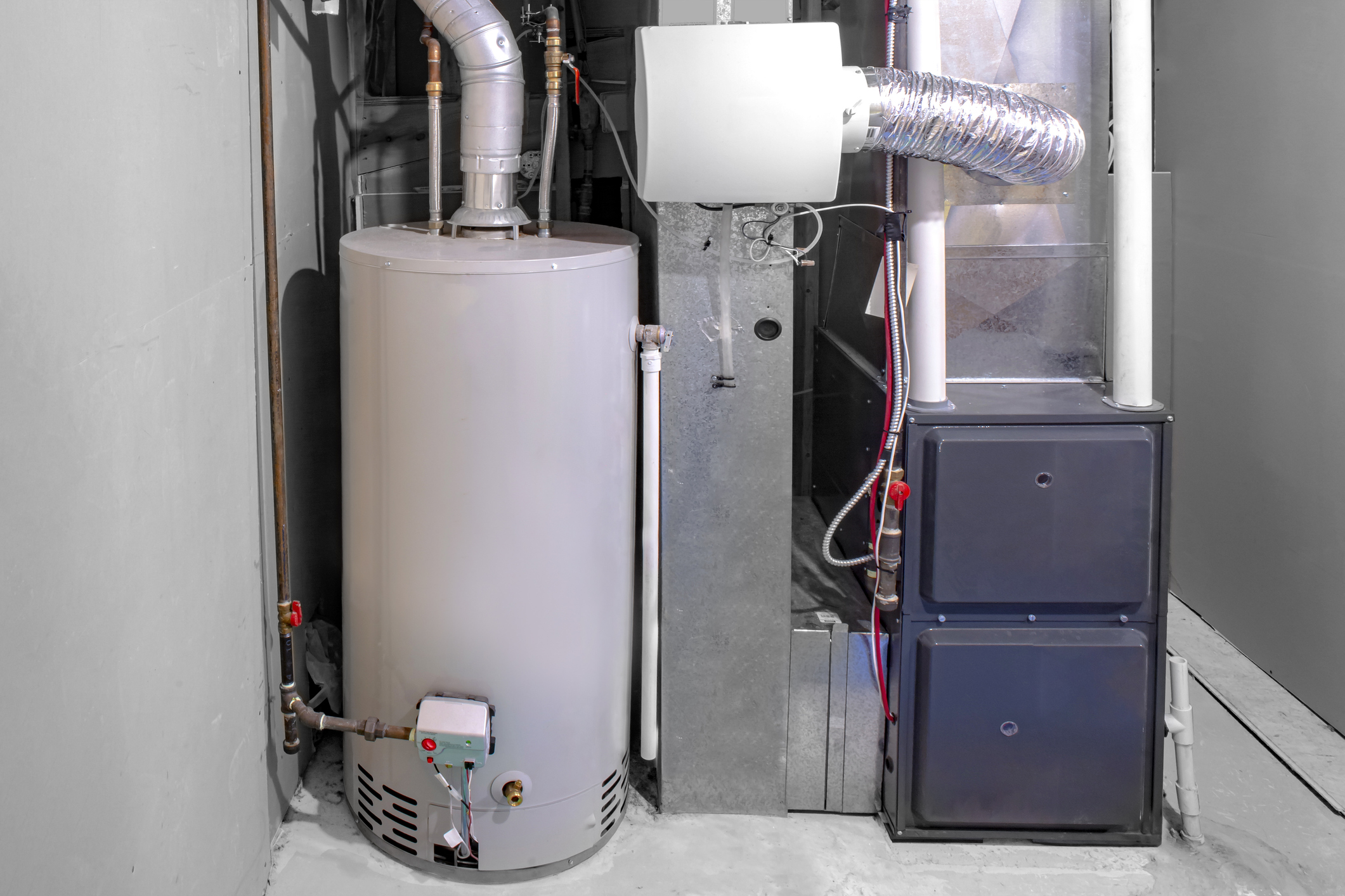 A modern furnace and gas water heater set up in the utility room of a residential home to help lower gas bills.