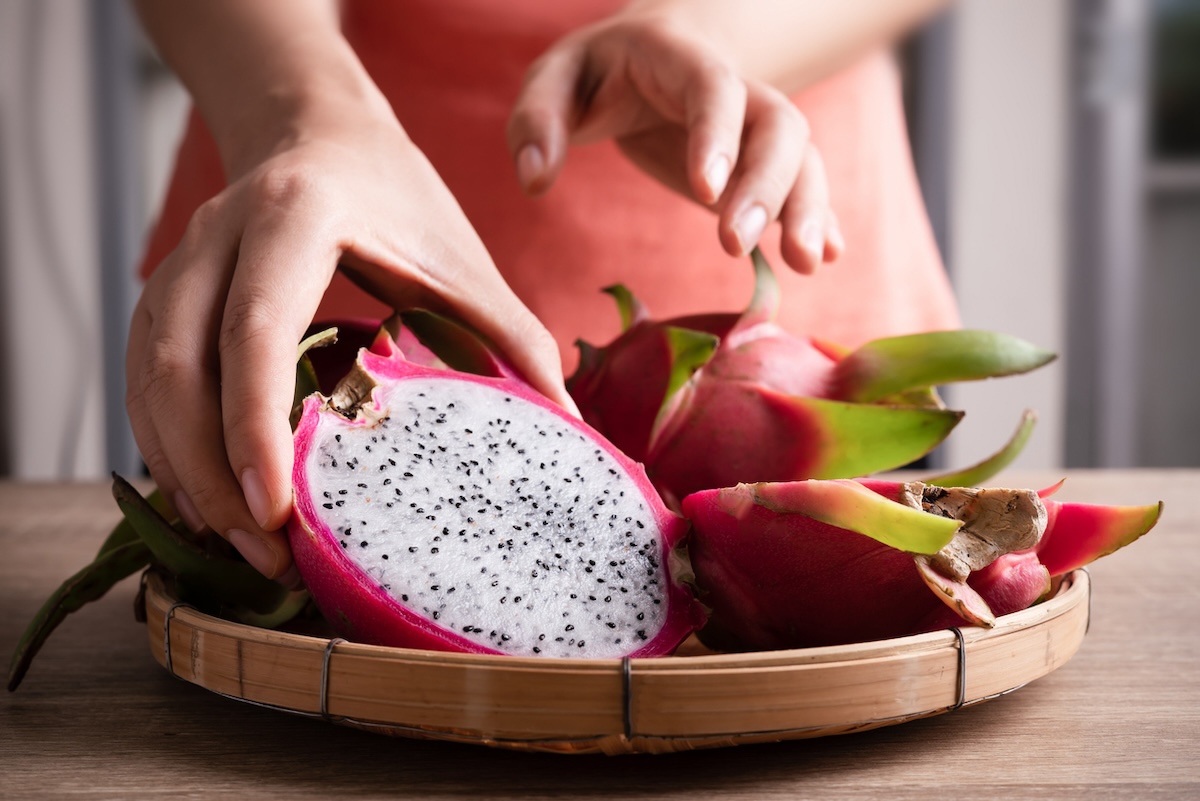 A person serving sliced dragon fruits for breakfast.